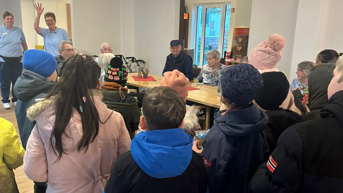 Kinder singen in den Neuen Höfen für die Bewohner*innen und überreichen die Weihnachtspost. Kinder singen in den Neuen Höfen für die Bewohner*innen und überreichen die Weihnachtspost.
