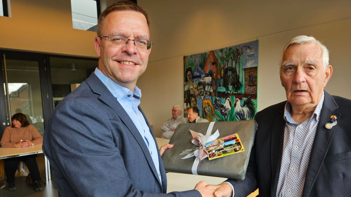 Bürgermeister Stephan Willudda (l.) nimmt ein Geschenk des belgischen Delegationsleiters Herman Cooremans (r.) entgegen.